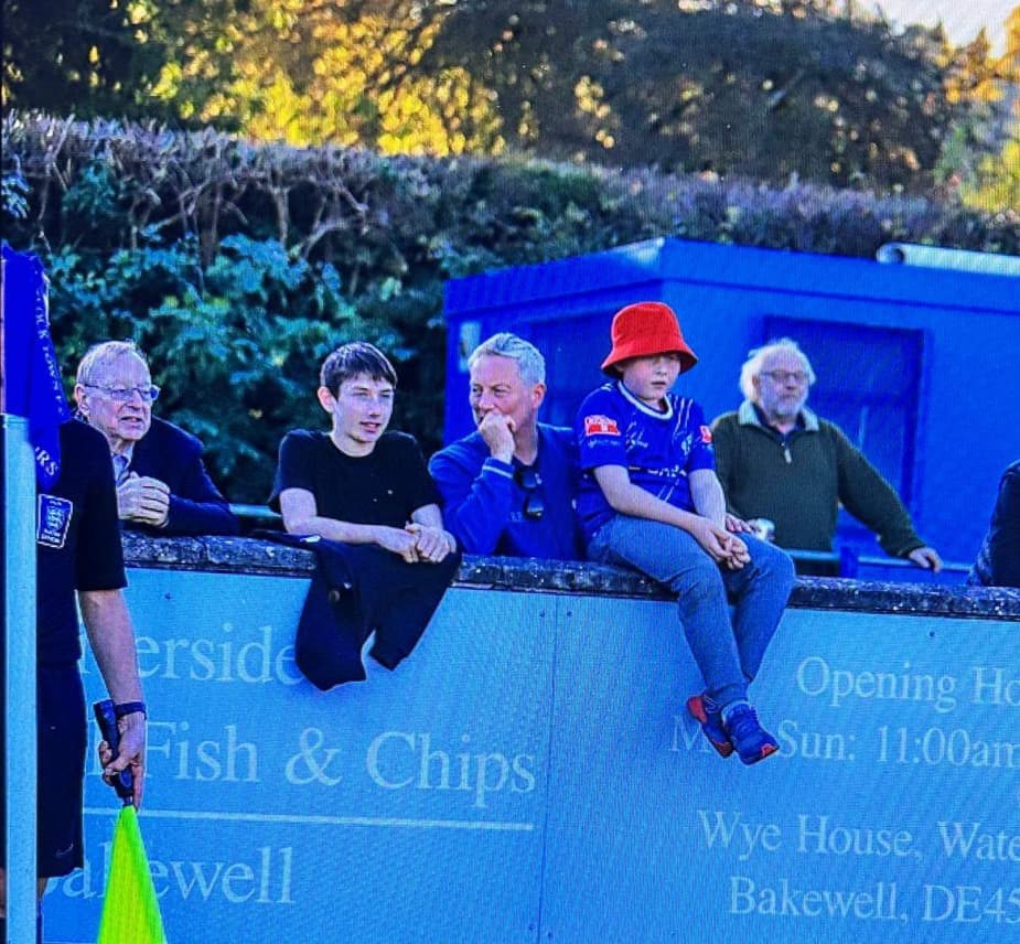 Away fans watching a football match from beside the pitch